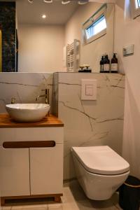 a white bathroom with a sink and a toilet at Jej i Jego - Eleganckie domki z balią na wyłączność in Niewiesze