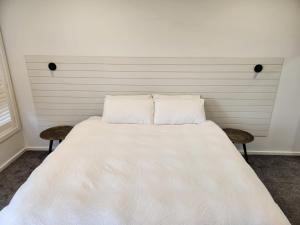 a large white bed with two chairs in a room at Bullseye in Yarrawonga