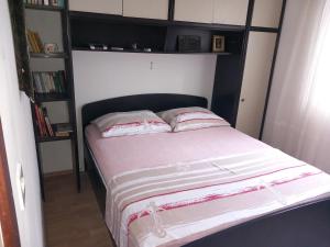 a bed with two pillows on it in a bedroom at Apartment Bella in Trogir