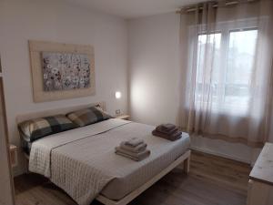 sypialnia z łóżkiem z dwoma ręcznikami w obiekcie Ca Giardina CIPAT 022104-AT-012586 w mieście Levico Terme