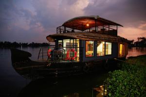 a boat on the water with a person on it at Honeymoon Houseboat in Alleppey