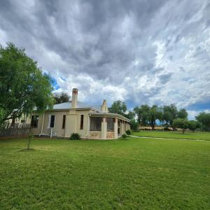 a house on a field with a grass yard at Karoo Leeu Self Catering in Oudtshoorn