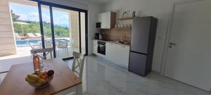 a kitchen with a table with a bowl of fruit on it at Apartmani Mariosa in Vrbnik