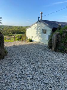 a gravel driveway in front of a white building at Moorland Breeze in Bodmin