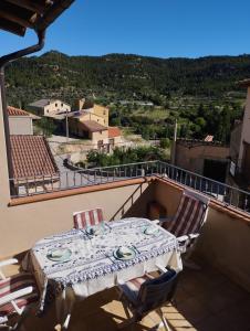 una mesa y sillas en un balcón con vistas en CASA RURAL LES ROQUETES, en Ráfales