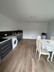 a kitchen with a table and a washing machine at Chambre Élégante Lisa in Bastia