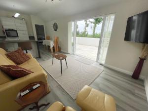 ein Wohnzimmer mit einer Couch und einem Tisch und einem Fernseher in der Unterkunft Sunnyside Cow Shed one bedroom central Cornwall in Truro