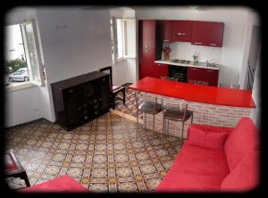 a living room with a red couch and a kitchen at Casa Flora in San Terenzo