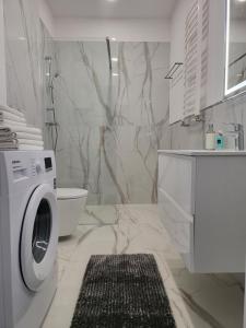 une salle de bain blanche avec une machine à laver à l'intérieur dans l'établissement Bursztynek - Luxoro Park, à Ustka