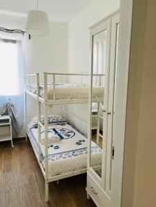 2 Etagenbetten in einem Zimmer mit Spiegel in der Unterkunft Domo Mea in La Caletta