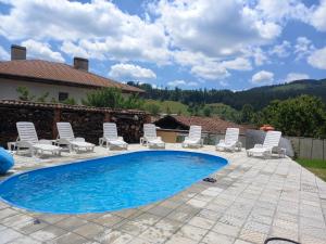a patio with chairs and a swimming pool at Kъща за гости Демария in Koprivshtitsa