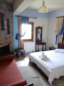 a bedroom with a bed and a fireplace at Hotel Erotas in Agios Dimitrios