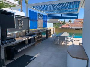 d'une terrasse avec un barbecue, une table et des chaises. dans l'établissement La casa del sol villa de luxe, à Ciudad Quesada