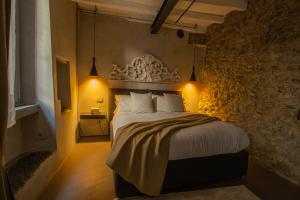 a bedroom with a large bed with a stone wall at Pietralago, Casa con vista sul Lago in Blevio
