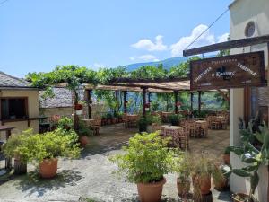 a patio of a restaurant with tables and potted plants at Hotel Erotas in Agios Dimitrios