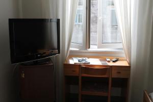 Televízia a/alebo spoločenská miestnosť v ubytovaní Hotel Esperia