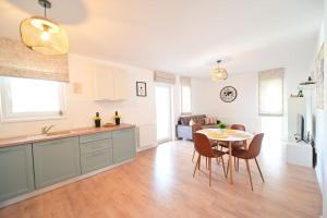Una cocina y una sala de estar con mesa y sillas. en Spacious and comfy in Sibiu, en Sibiu