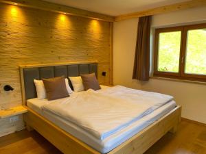 a bedroom with a large white bed with a window at Wimbachlehen in Ramsau