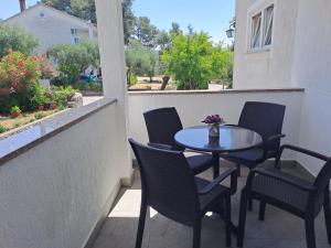 un patio con tavolo e sedie sul balcone. di Studio Apartments Maslinik a Krk