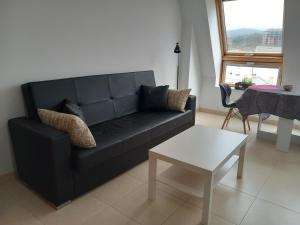 a living room with a black couch and a table at Playa Caosa in San Ciprián