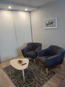 una sala de espera con 2 sillas y una mesa en Vanilės home en Šiauliai