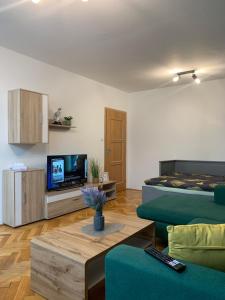 a living room with a bed and a couch and a tv at Victory apartmán in Šamorín