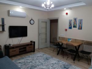 a living room with a television and a table and chairs at Çınar Residance in Demre