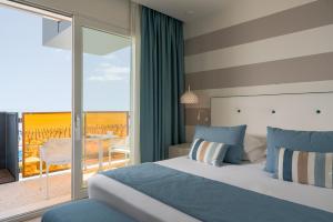 a hotel room with a bed and a balcony at Hotel Orient & Pacific in Lido di Jesolo