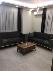 a living room with black couches and a coffee table at LATİBULE süit otel in Pelitli