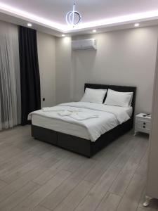 a bedroom with a large bed with white sheets at LATİBULE süit otel in Pelitli