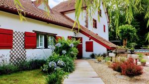 una casa con puertas rojas y una pasarela en Le Moulin de Saubrigues, en Saubrigues