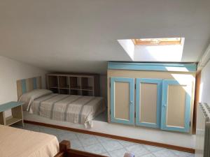 マリーナ・ディ・ビッボーナにあるParco Vacanze La Rosa dei Ventiのベッドルーム1室(ベッド1台、青いキャビネット付)