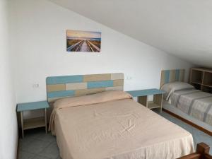 1 dormitorio con 1 cama y 2 mesas en Parco Vacanze La Rosa dei Venti, en Marina di Bibbona