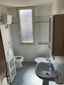 マリーナ・ディ・ビッボーナにあるParco Vacanze La Rosa dei Ventiのバスルーム(洗面台、トイレ付)、窓が備わります。
