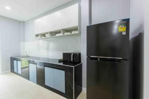 uma cozinha com um frigorífico preto num quarto em Private Pool villa & warm water. em Ban Mae Kon