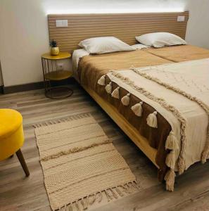 1 dormitorio con 1 cama grande y 1 silla amarilla en Casa da Grota do Bravo, en Nordeste