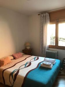 1 dormitorio con 1 cama con toallas en Apartament al cor de la Vall de Camprodon, en Vilallonga de Ter
