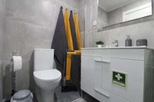 a bathroom with a white toilet and a sink at Varanda do Bonfim in Setúbal +31 photos