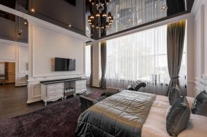1 dormitorio con 1 cama grande y TV en Grand Royal, en Chernivtsi