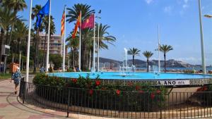 a fountain in the middle of a park with palm trees at Mar y castillo in Cullera