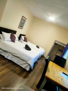 a bedroom with two beds and a table at The Oldtown Apartments in Cookstown