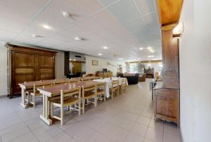 un comedor con una mesa larga y sillas en APF France handicap - Ferme Léonie, en Saint-Laurent-en-Grandvaux