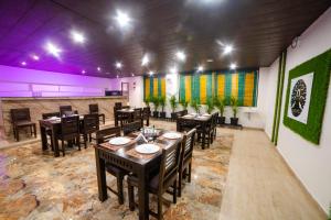 a restaurant with wooden tables and chairs and colorful walls at MURALI KRISHNA APART HOTEL in Kākināda