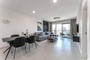 a living room with a table and a couch at Holysuite Savyon View Tower in Jerusalem