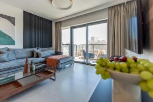 a living room with a couch and a table at Holysuite Savyon View Tower in Jerusalem