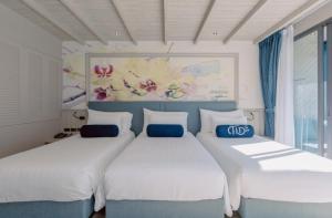 two beds in a room with white and blue at Hotel Tide Phuket Beach front - SHA Plus in Phuket Town