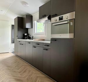 a kitchen with black and white cabinets and a window at Landzicht Natuur Rust en Ruimte in Oosterwolde
