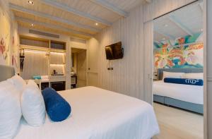 a hotel room with a bed and a tv at Hotel Tide Phuket Beach front - SHA Plus in Phuket Town