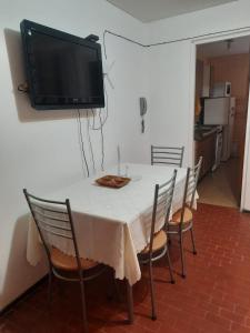 門多薩的住宿－CONSORCIO ARIZU，一张带椅子的白色桌子和墙上的电视