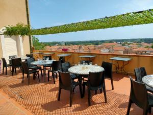 eine Terrasse mit Tischen und Stühlen auf dem Dach in der Unterkunft Au Remp'Arts in Elne